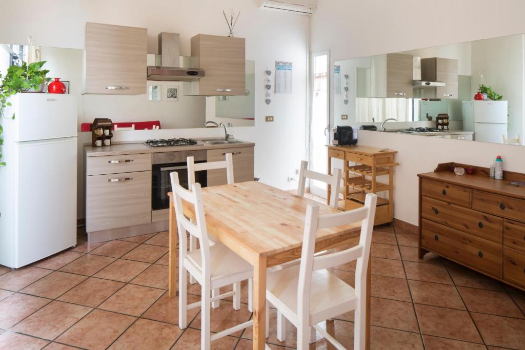uma cozinha com uma mesa de madeira e electrodomésticos brancos em Alloggio turistico Giacomo Puccini em Viterbo