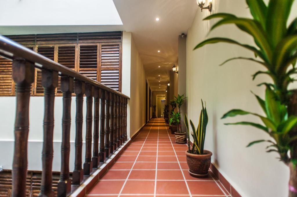 a hallway with potted plants and a staircase at Armenian Suite in George Town