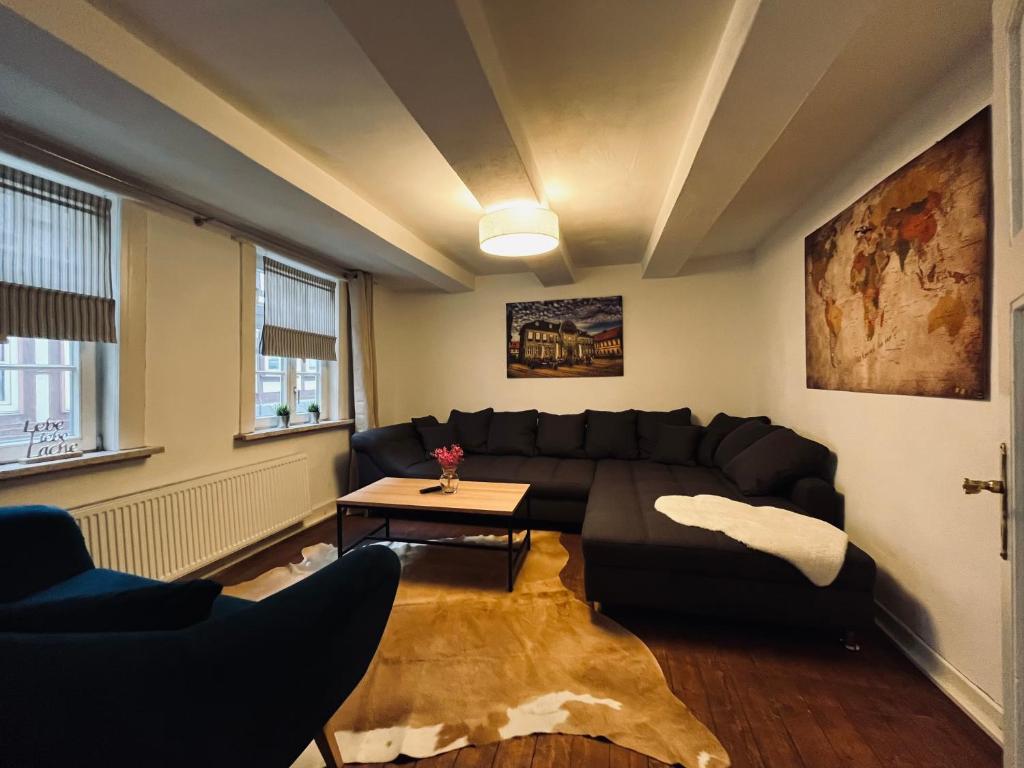 a living room with a black couch and a table at Stabwerk Goslar Altstadt in Goslar