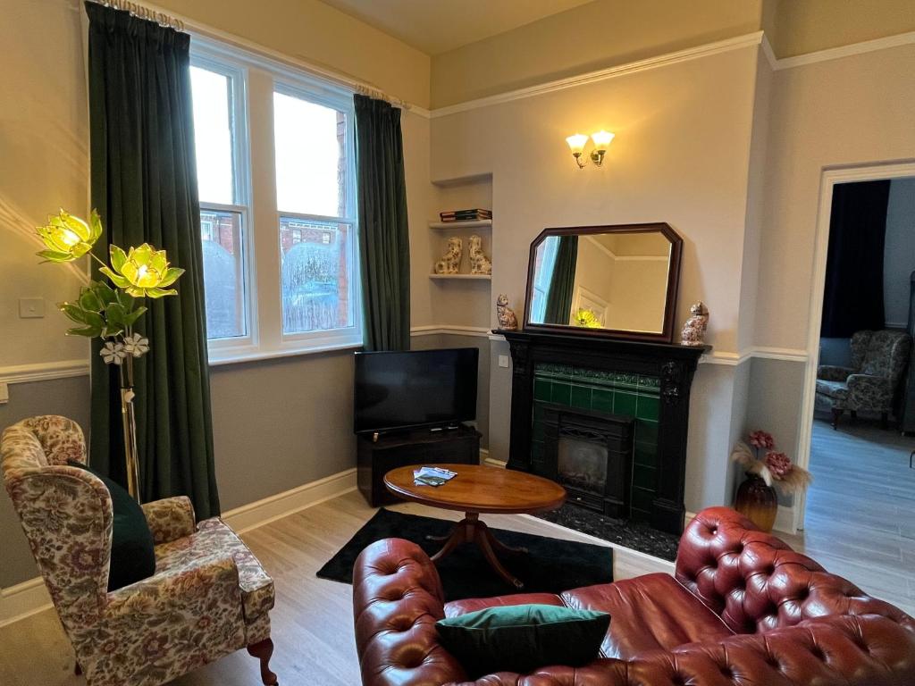 a living room with a couch and a fireplace at Red Gables - Ground Floor in Carlisle