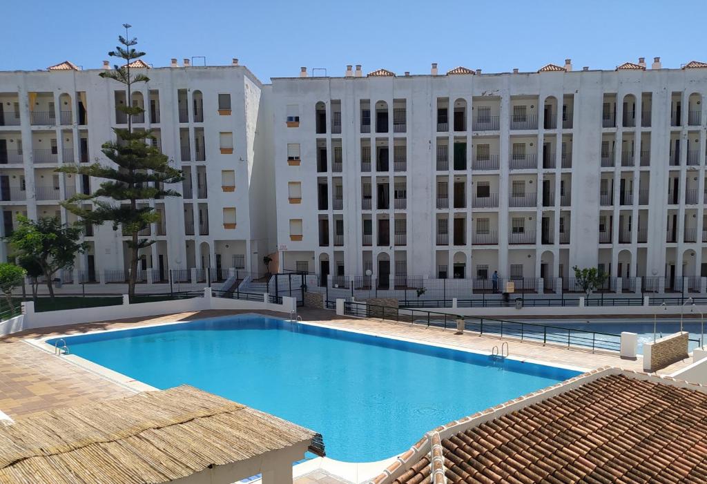 a swimming pool in front of a large building at Un lugar llamado descanso in Matalascañas