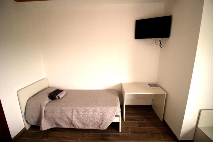 una piccola camera da letto con un letto e una scrivania di B&B Ca' Bianca ad Adria