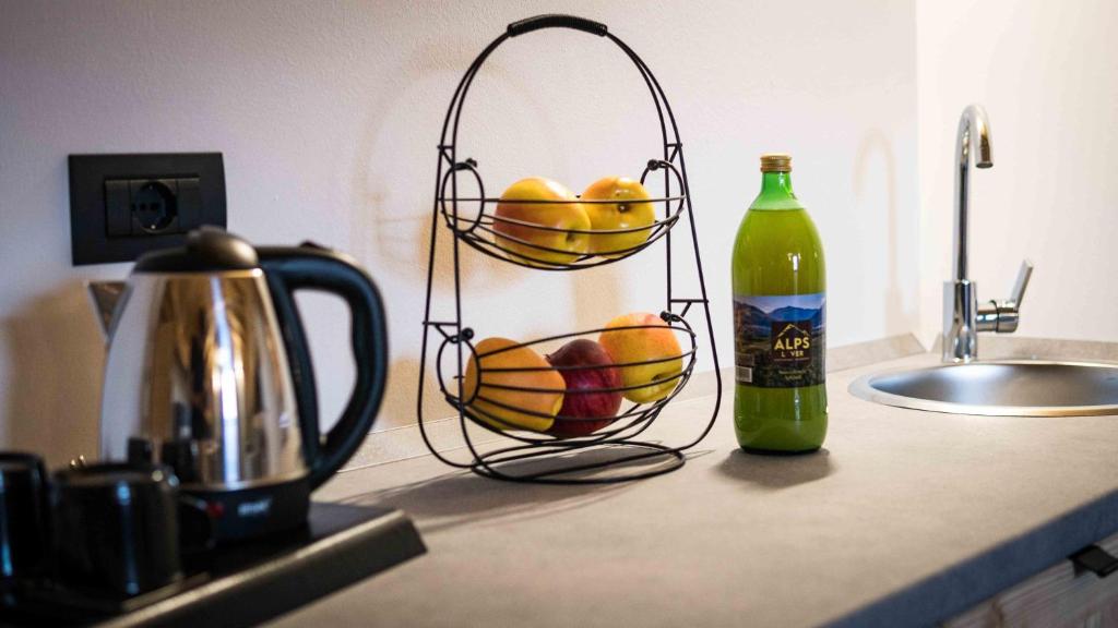 a kitchen counter with two baskets of fruit and a bottle at ALPS LOVER in Campodenno