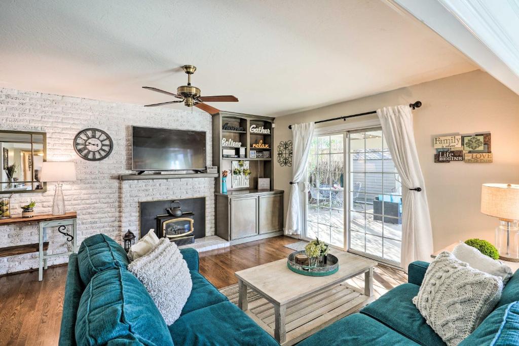 a living room with a blue couch and a fireplace at Sutter Creek Retreat with Patio Near Main St! in Sutter Creek