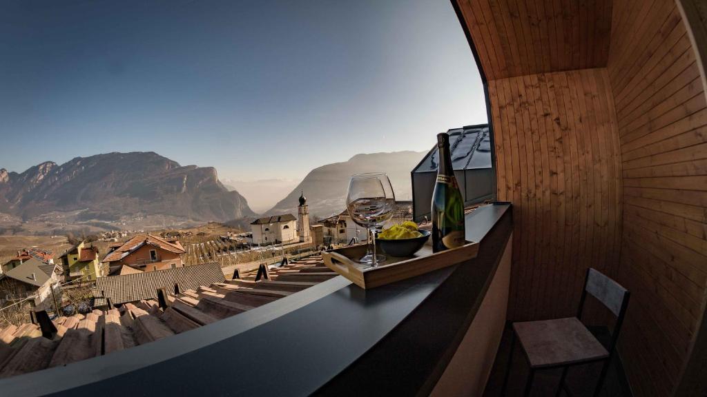 a balcony with a wine glass and a view of a mountain at ALPS LOVER in Campodenno