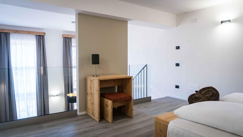 a bedroom with a bed and a table with a chair at ALPS LOVER in Campodenno