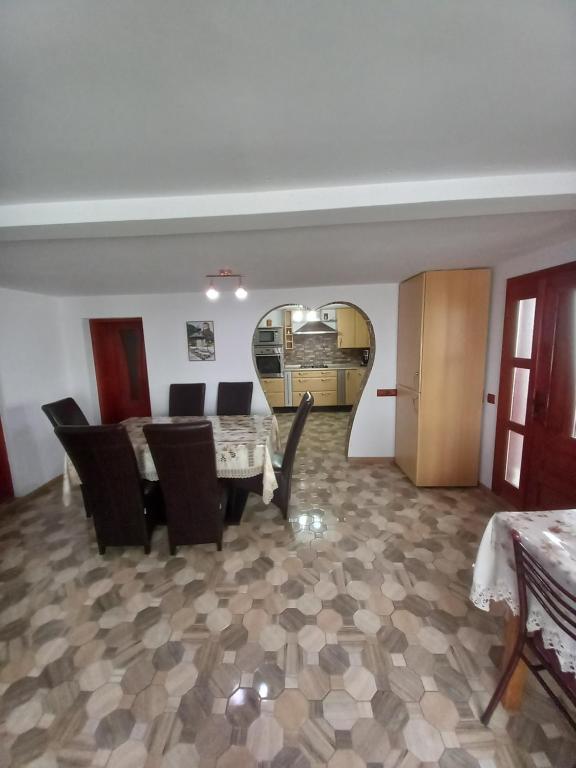 a dining room with a table and black chairs at Casa David in Gîrda de Sus