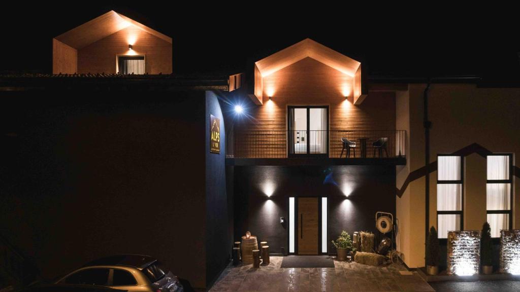 una casa con luces al costado de ella por la noche en ALPS LOVER en Campodenno