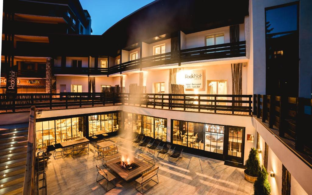 an apartment building with a patio with a fire pit at Rock Noir & Spa in La Salle-les-Alpes