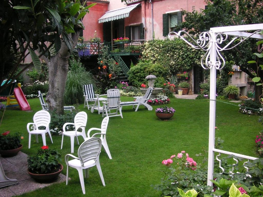 un gruppo di sedie bianche sedute in un cortile di Casa Eden a Venezia