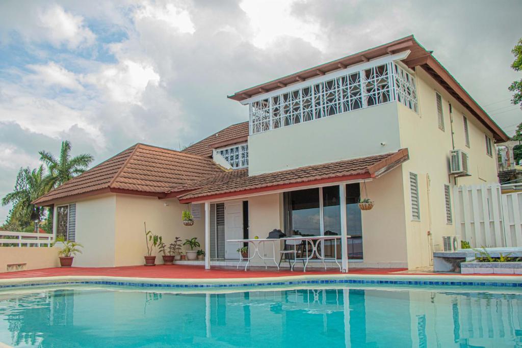 a house with a swimming pool in front of it at The Whytehouse Villa in Montego Bay