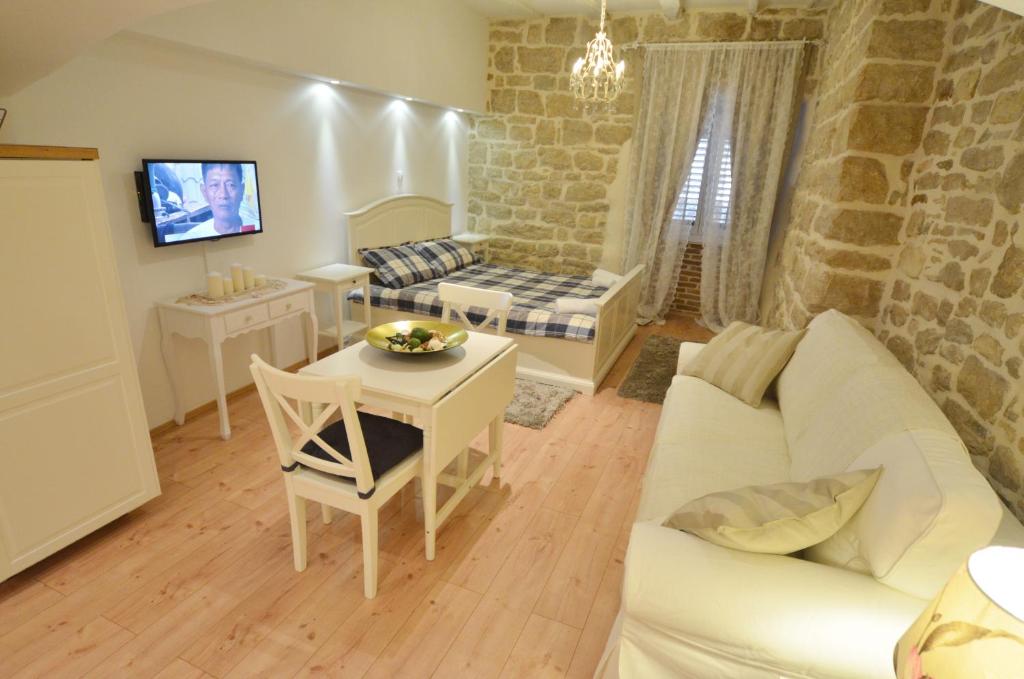 sala de estar con sofá blanco y mesa en Studios Villa Rossella 4, en Rovinj