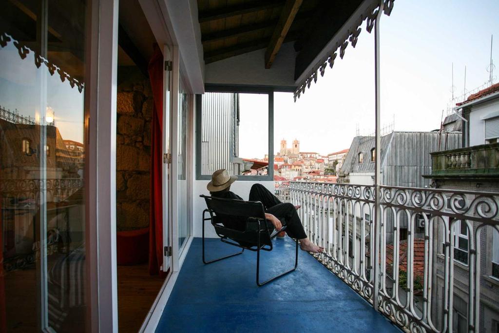 ポルトにあるBelomonte 20 Apartments Porto World Heritageのバルコニーの椅子に座る女性