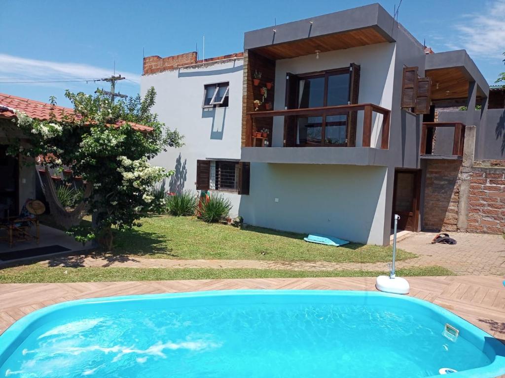 Villa con piscina frente a una casa en Férias em Torres, en Torres