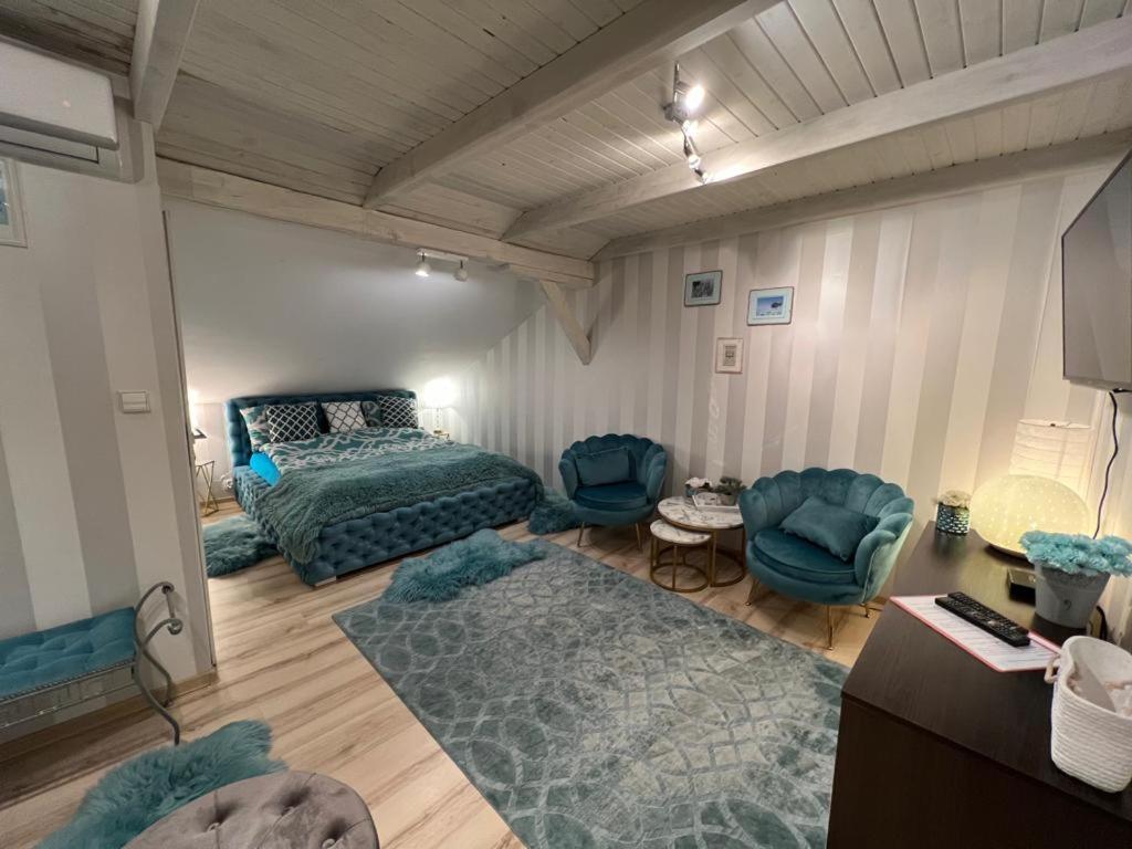 a bedroom with a bed and a couch and chairs at Comfort Zone Ostróda BLUE in Grabinek