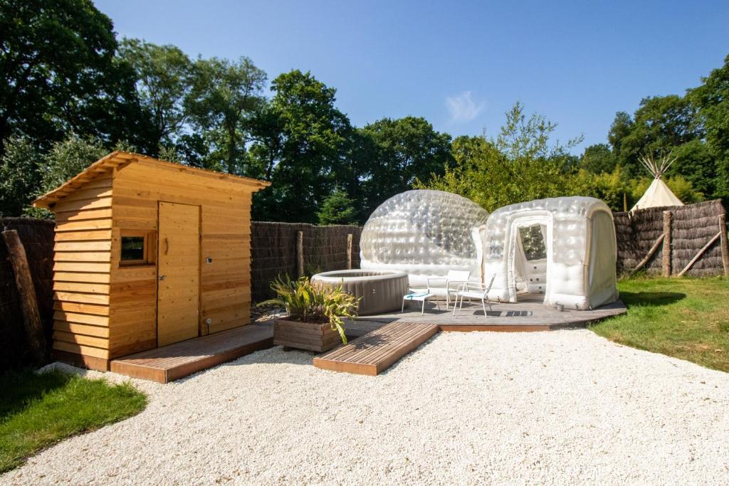 a backyard with a dog house and a greenhouse at Domaine Arvor & Spa in Lanvallay