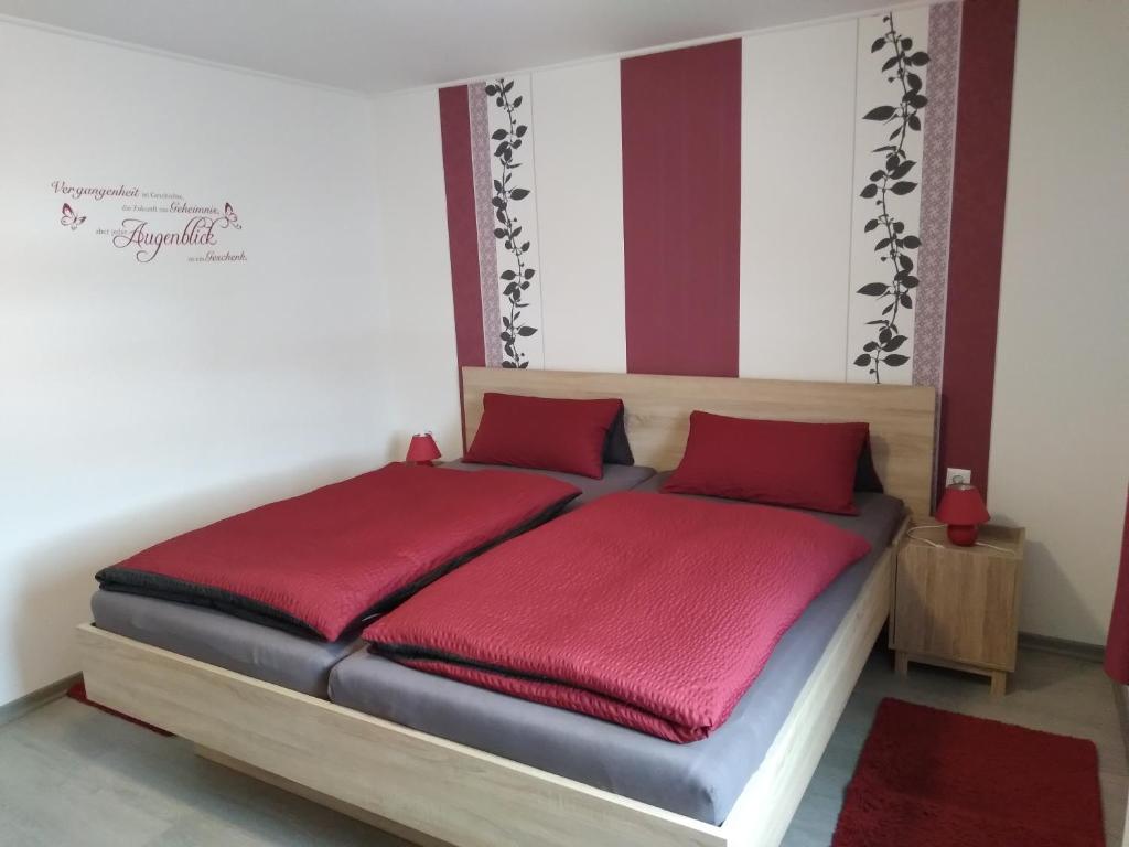 a bed in a room with red pillows on it at Ferienwohnung Waldesruh in Lam