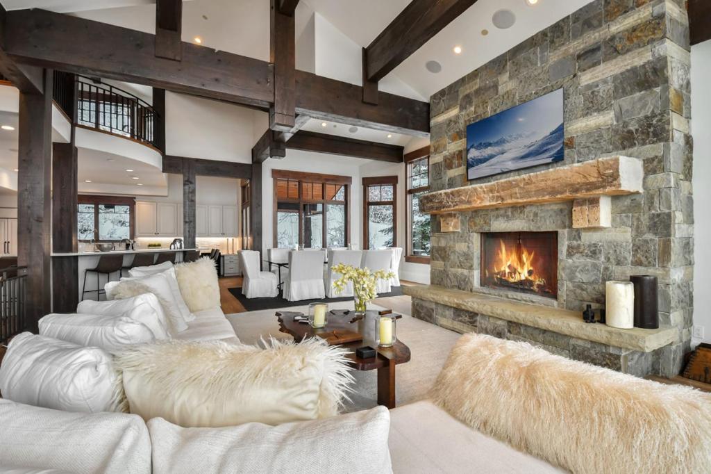 a living room with couches and a stone fireplace at Deer Hollow Chalet in Park City