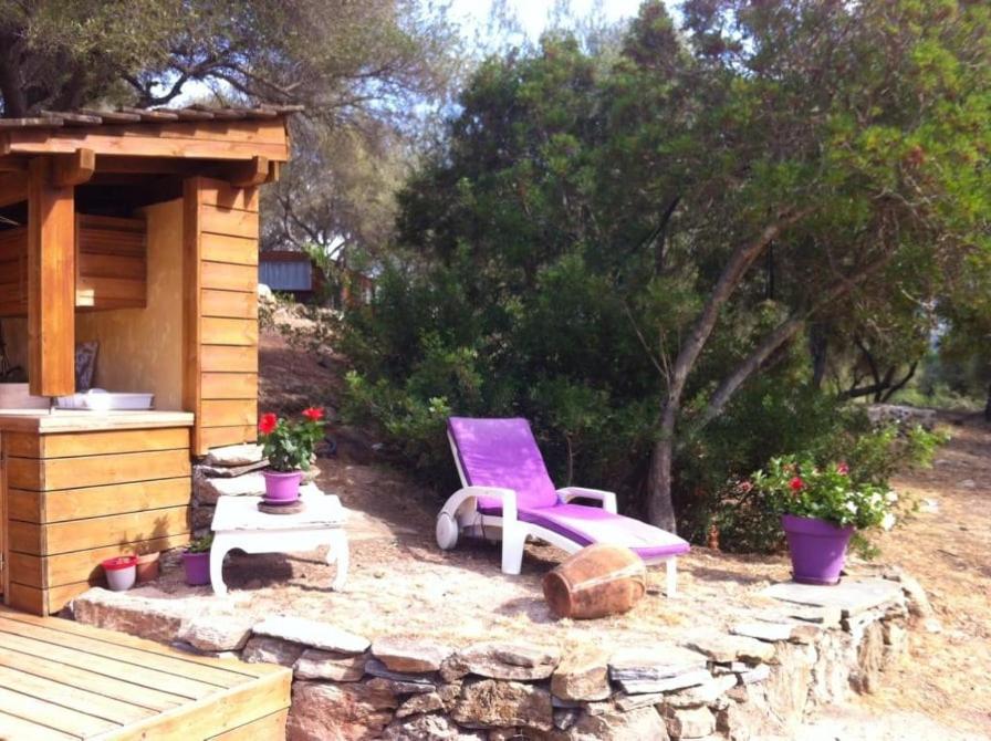 a purple chair sitting next to a wooden cabin at Bergerie tout confort L'immortelle in Saint-Florent