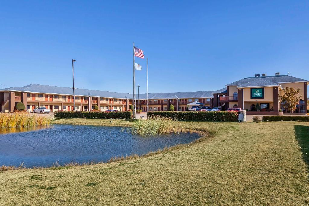 a hotel with a pond in front of a building at Quality Inn & Suites Owasso US-169 in Owasso