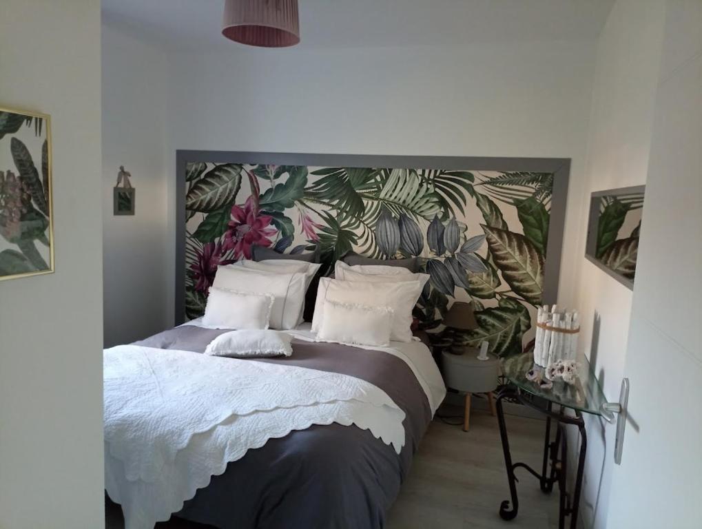 a bedroom with a large bed with plants on the wall at Maison neuve et chaleureuse in Morcenx