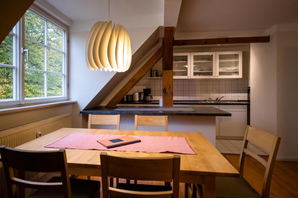 eine Küche mit einem Holztisch mit Stühlen und einer Treppe in der Unterkunft "goethezimmer" Ferienwohnungen Am Schloss in Weimar
