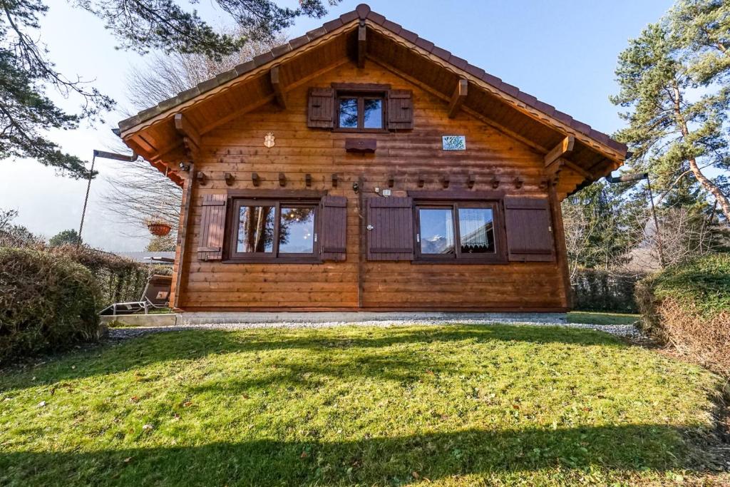 a log cabin with a large yard in front of it at Le Chalet Bonheur in Lathuile