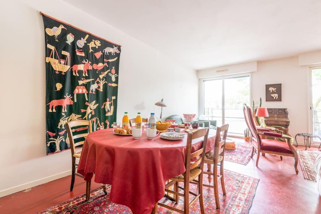 une salle à manger avec une table et des chaises rouges dans l'établissement Port Royal Apart de Charme-Parking-Cœur de Ville, à Nantes