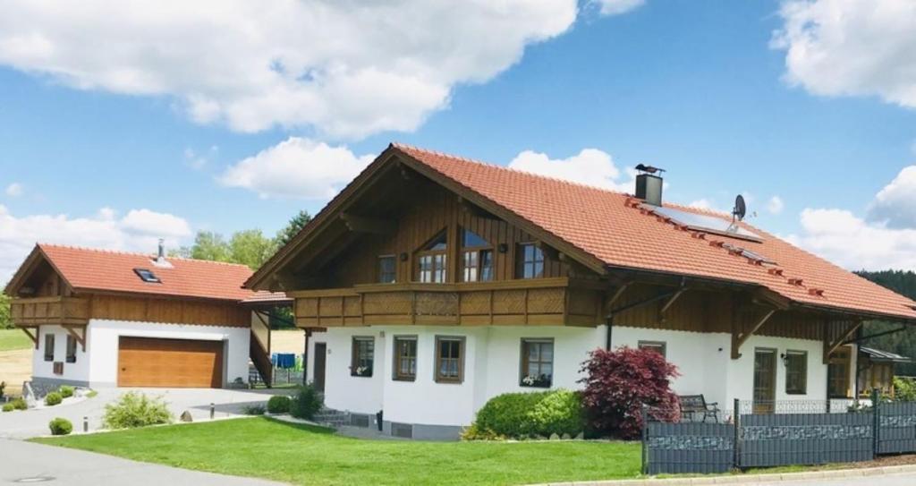 ein Haus mit einem Holzdach in der Unterkunft Ferienwohnung "Panoramablick" in Achslach
