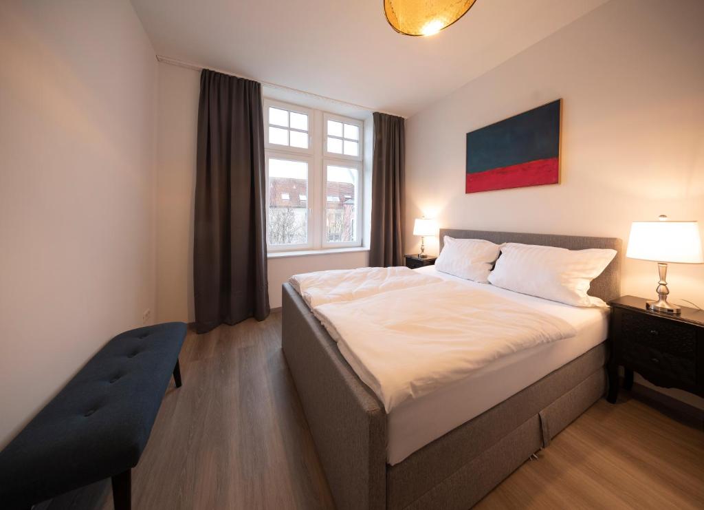 een slaapkamer met een groot bed en een raam bij Gemütliches Apartment direkt am Hafen von Dortmund in Dortmund
