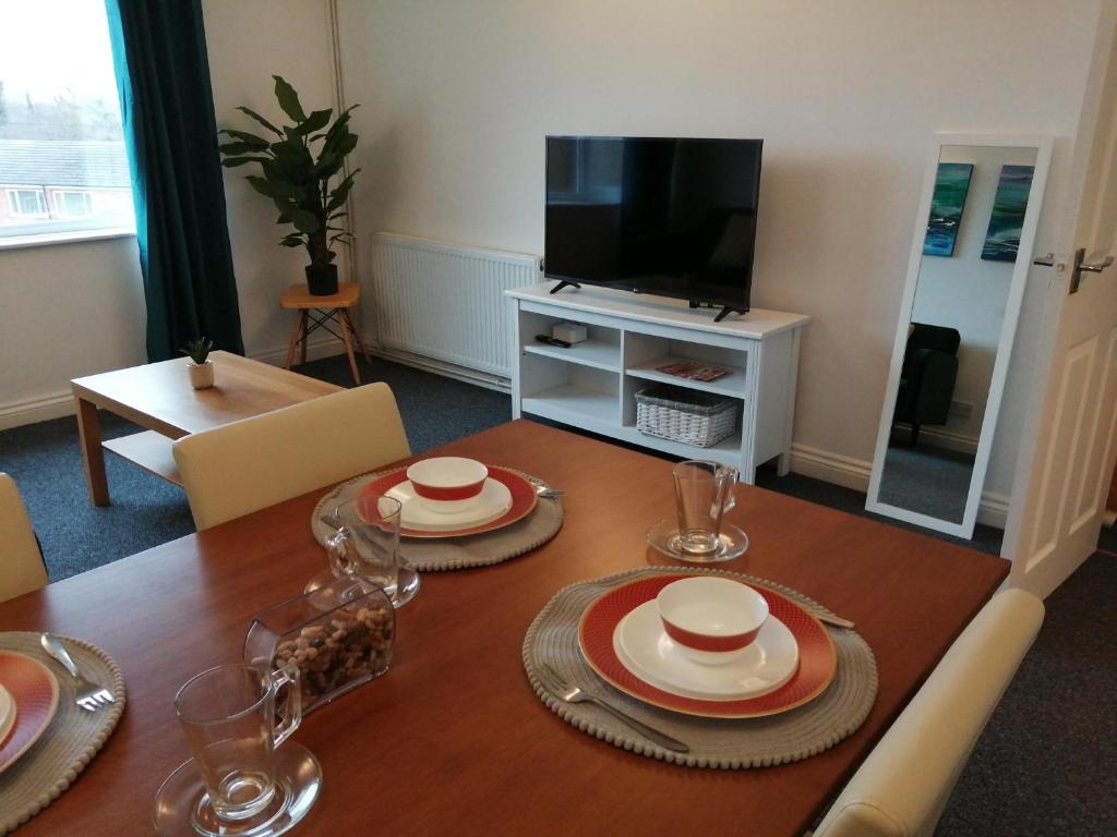 una sala da pranzo con tavolo e TV di The Hillside Apartment - King's Norton Birmingham a Kings Norton