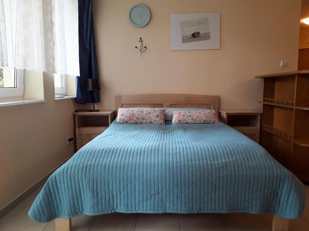 a bedroom with a bed with a blue comforter at Apartament Morskie Oko in Międzyzdroje