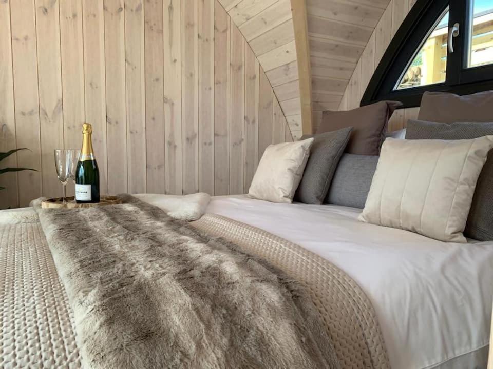 Orkney Lux Lodges - Hoy Lodge في سترومنيس: غرفة نوم مع سرير وزجاجة من النبيذ