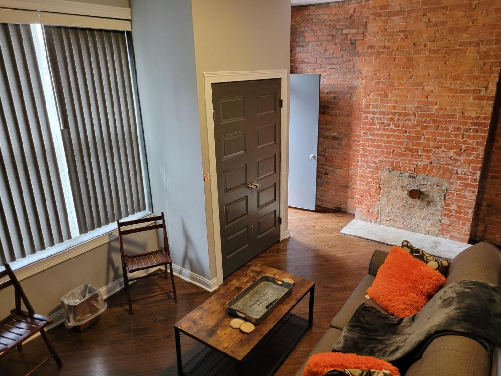 a living room with a couch and a brick wall at Modern Rustic split level with balcony in Cincinnati