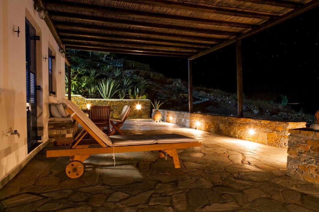 - une chaise en bois assise sur une terrasse la nuit dans l'établissement Aegean Paradise, Kythnos, Naousa, à Kythnos