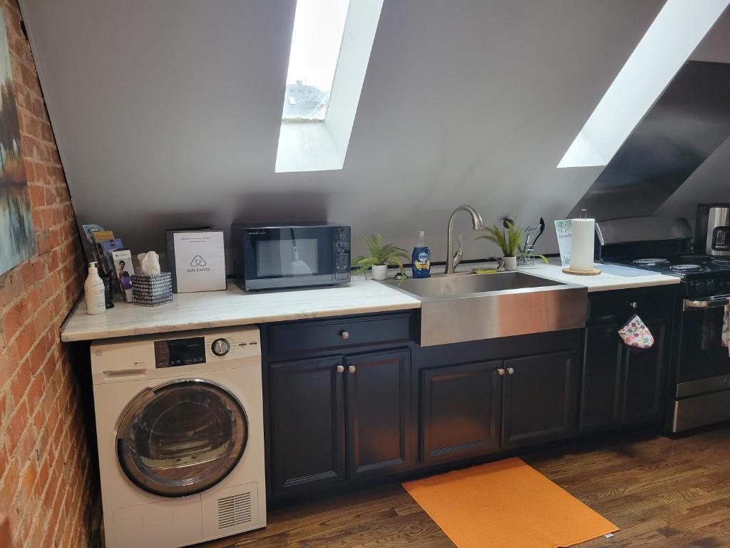 a kitchen with a washing machine and a sink at Modern Rustic split level with balcony in Cincinnati