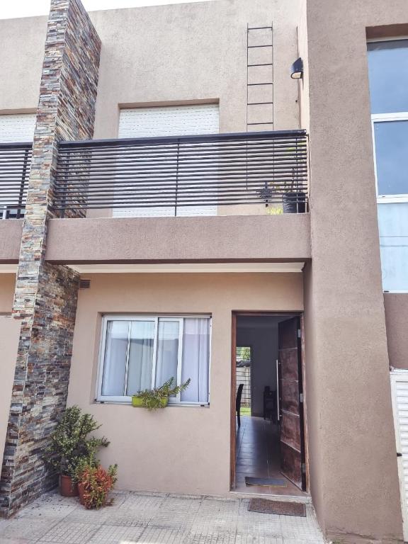 a house with a balcony on the side of it at Duplex 571 in Chascomús