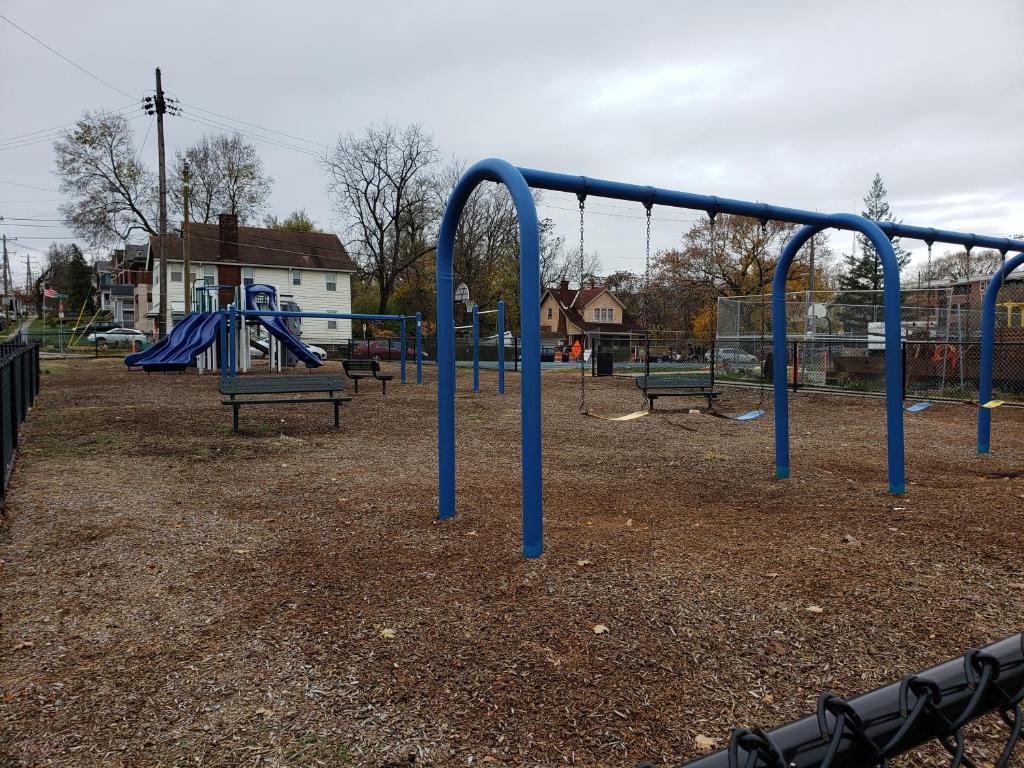an empty playground with blue bars in a park at Modern Rustic split level with balcony in Cincinnati