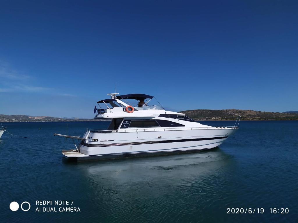 a white boat in the water on a lake at ΜΕΓΑΡΑ yacht Λιμανι Νέας Περάμου in Megara