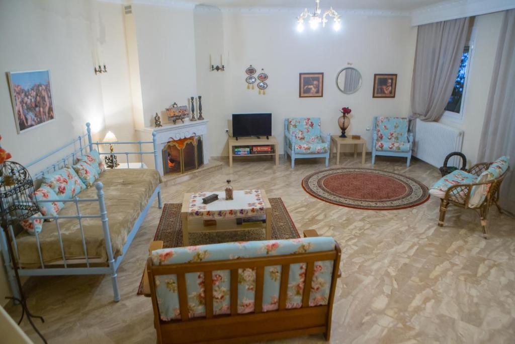 a living room with a couch and a table at Woods Cottage Σπίτι με Τζάκι κοντά στα Λουτρά Πόζαρ in Megaplátanos