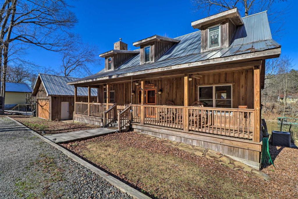 a large wooden house with a porch at Riverfront Heber Springs Home Spacious Deck! in Heber Springs