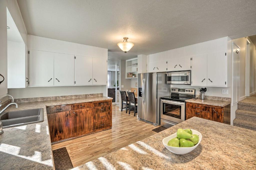 una cocina con armarios blancos y un bol de manzanas en una encimera en Sioux Center Split-Level Home with Game Room!, en Sioux Center
