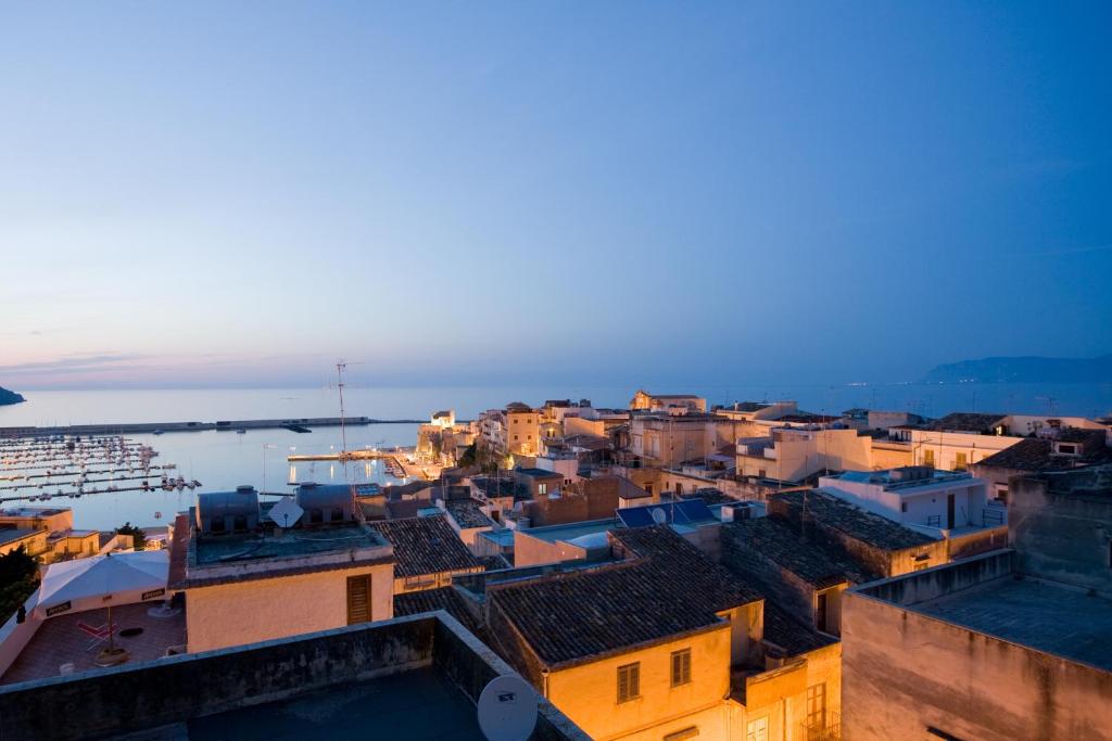 vista su una città con una barca in acqua di Sicilia Ovest - Domus Mariae Charming Apartments with Balcony a Castellammare del Golfo