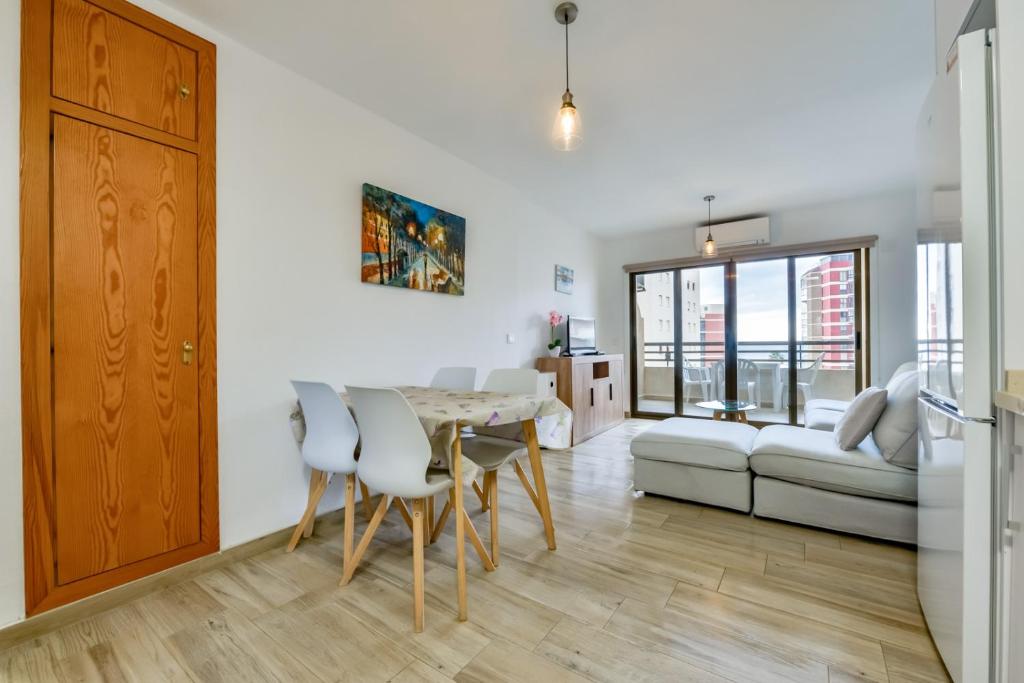 eine Küche und ein Wohnzimmer mit einem Tisch und Stühlen in der Unterkunft Apartamento "Casa Auri" con Piscina, Wi-fi y Parking Gratis in Calpe