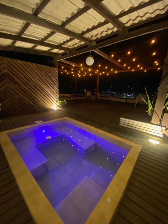 uma piscina à noite com luzes acesas em Villa Rustica Praia dos Anjos em Arraial do Cabo