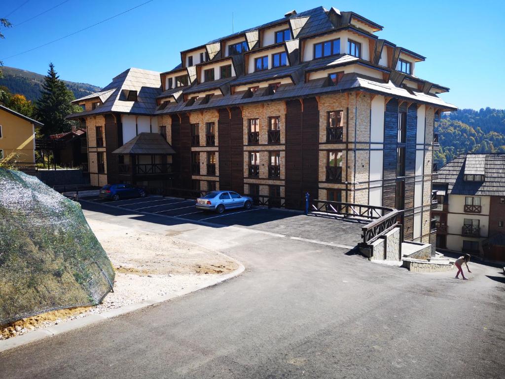 a person walking in front of a large building at Zoned II Kopaonik - Studio Njegomir in Kopaonik