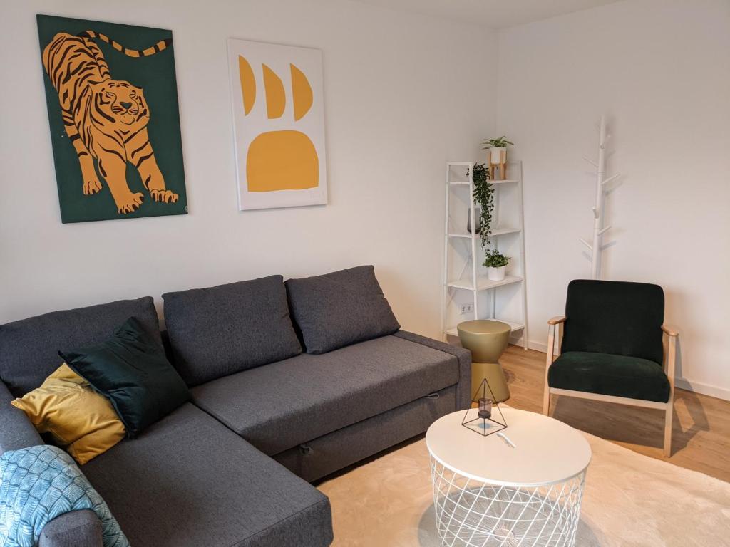 ein Wohnzimmer mit einem Sofa und einem Stuhl in der Unterkunft Zentrale und gemütliche Ferienwohnung in Winterberg nah an der Natur in Winterberg
