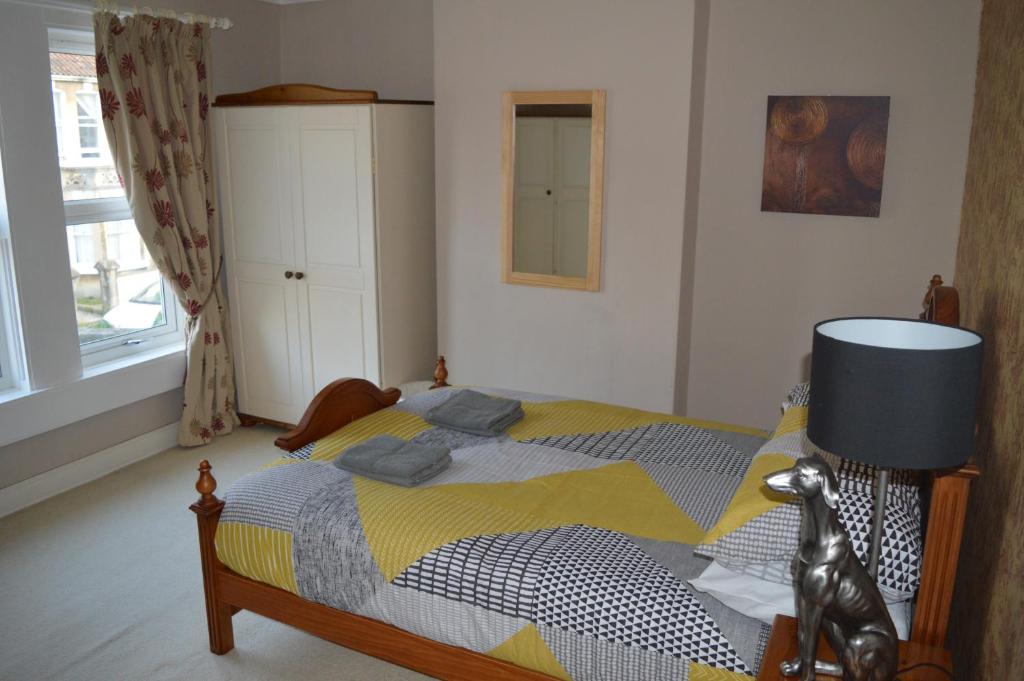 um quarto com uma cama com um cobertor amarelo e azul em The Crandale House Vacation Home em Bath