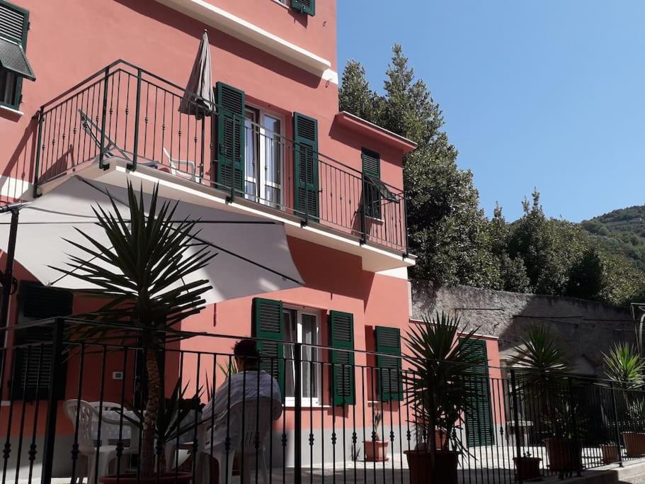 a man standing in front of a pink building at Casa Lisa in Finale Ligure