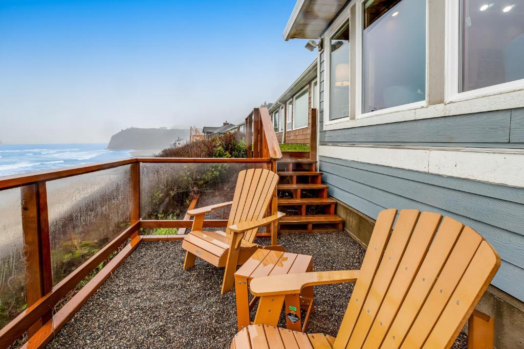 two chairs sitting on a balcony overlooking the ocean at Blue Sea Oceanfront Cottage in Oceanside